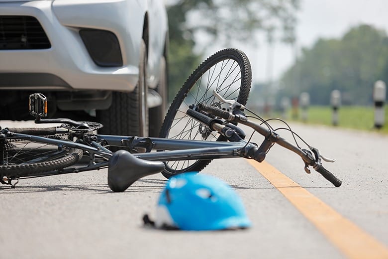 bike hit by car on road with helmet on ground