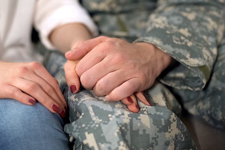 soldier and woman holding hands