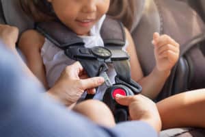 mom-buckling-happy-child-in-car-seat