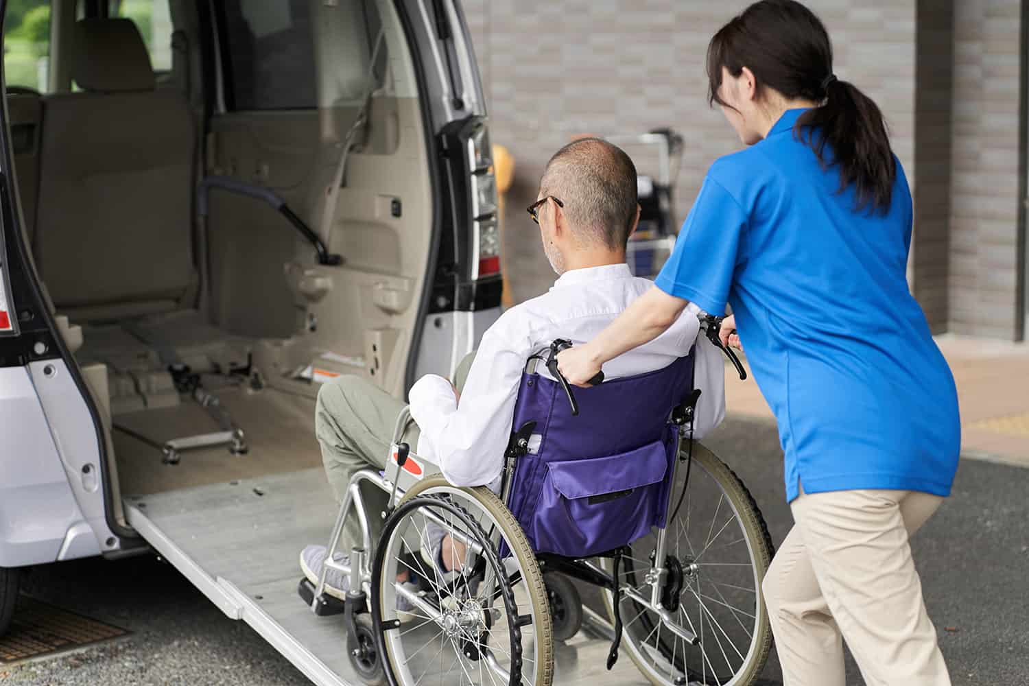 patient-transport Patient being transported into a handicap accessible van by a caregiver