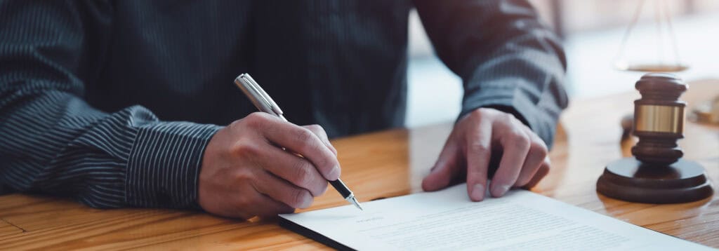 man signing insurance paperwork