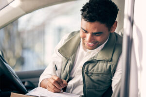 young man signing paperwork for insurance