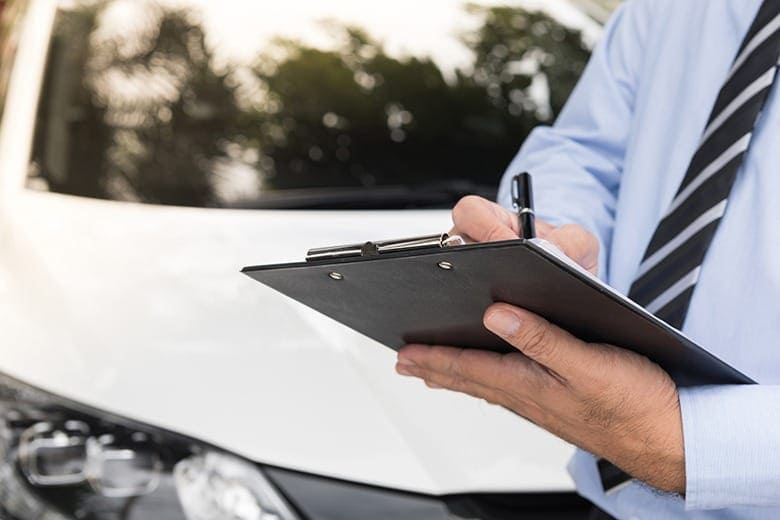 man writing on clipboard after accident