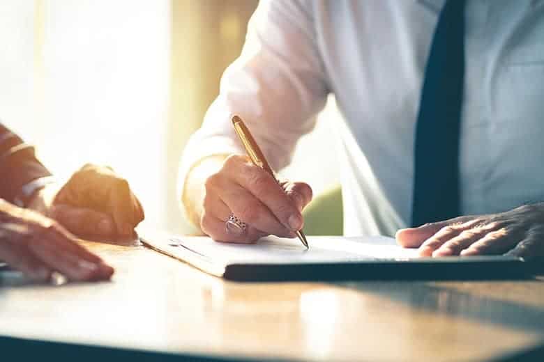 lawyer writing on paper with client
