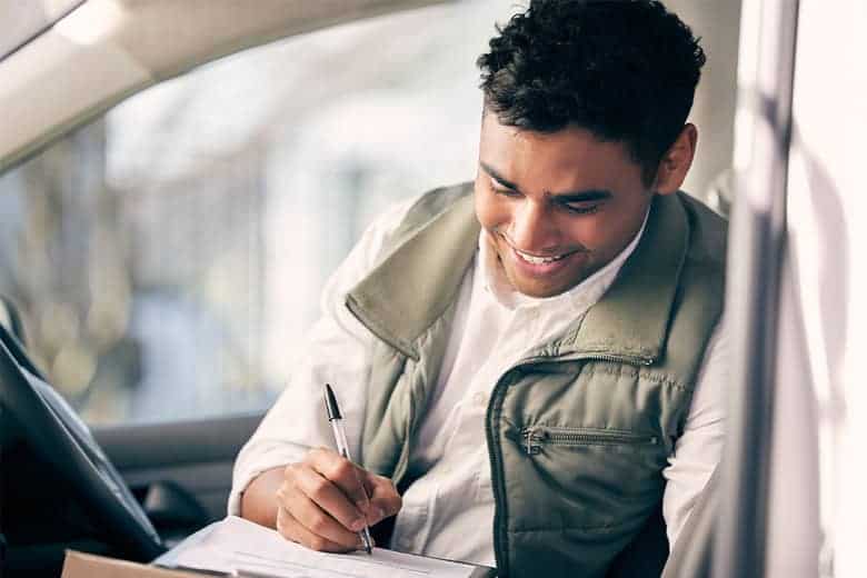 young man signing paperwork for insurance