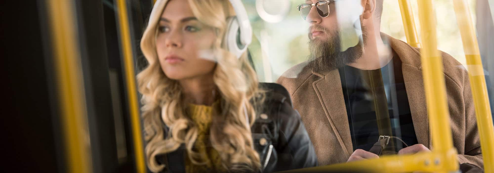 Young woman and man ride as passengers on a bus