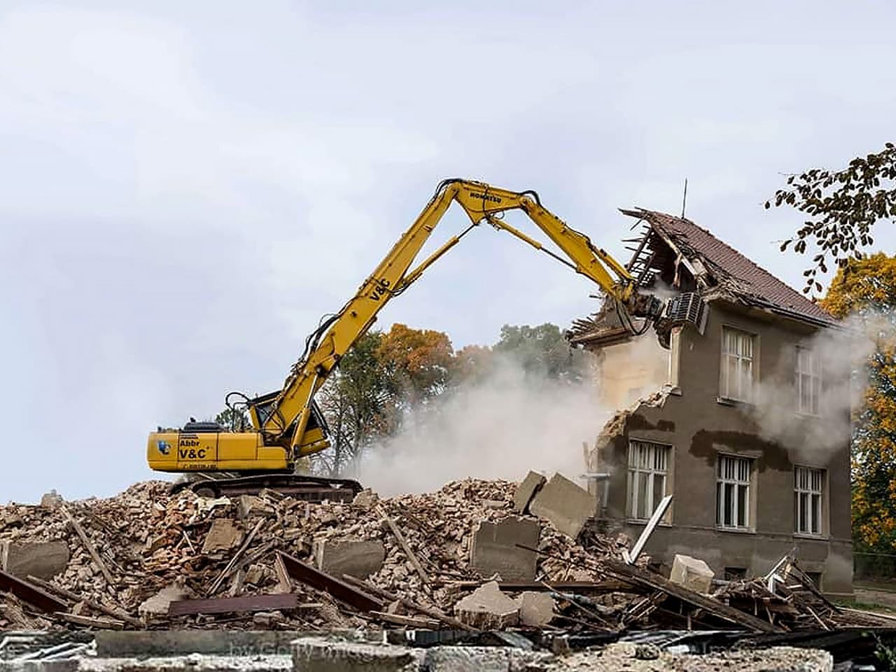 Excavator demolishing house