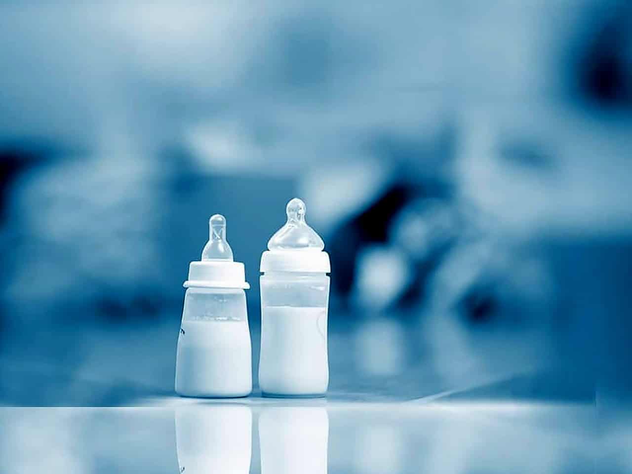 Two baby bottles with formula on counter