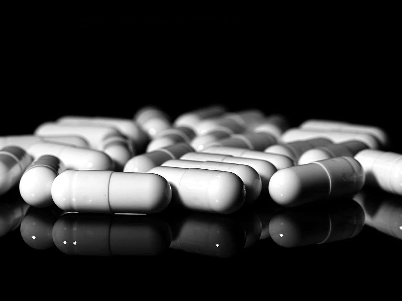 White capsule medication on black background