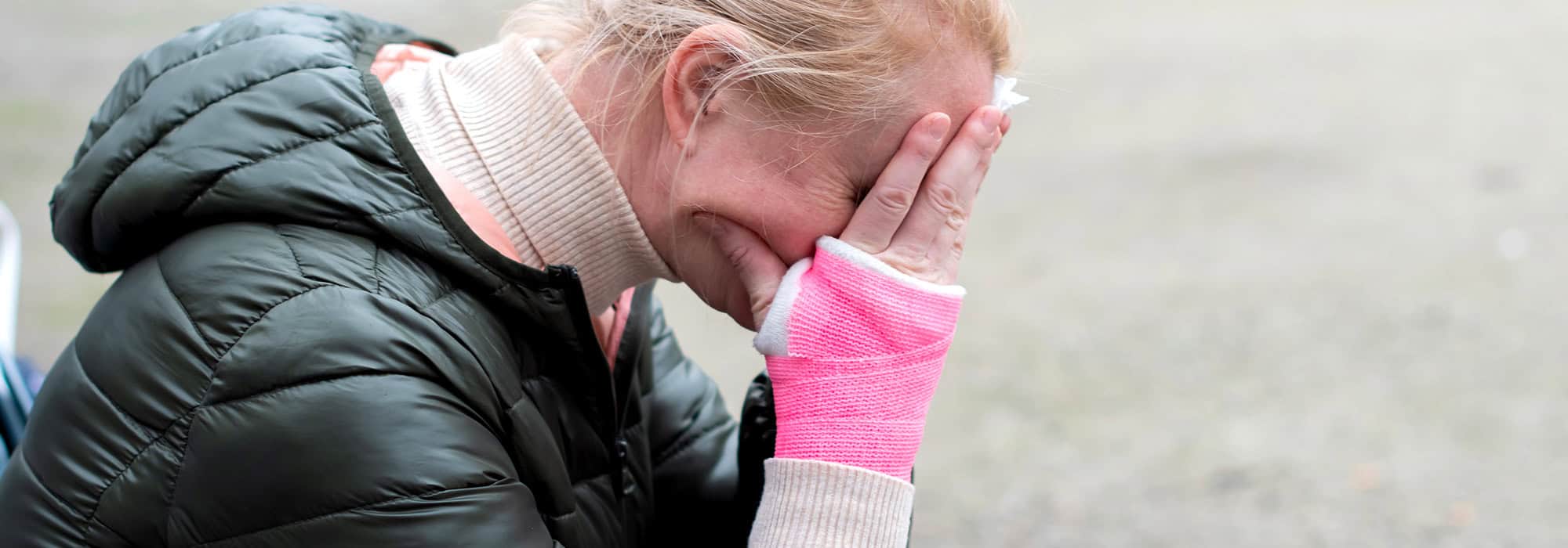 Woman covering her face with an injured arm