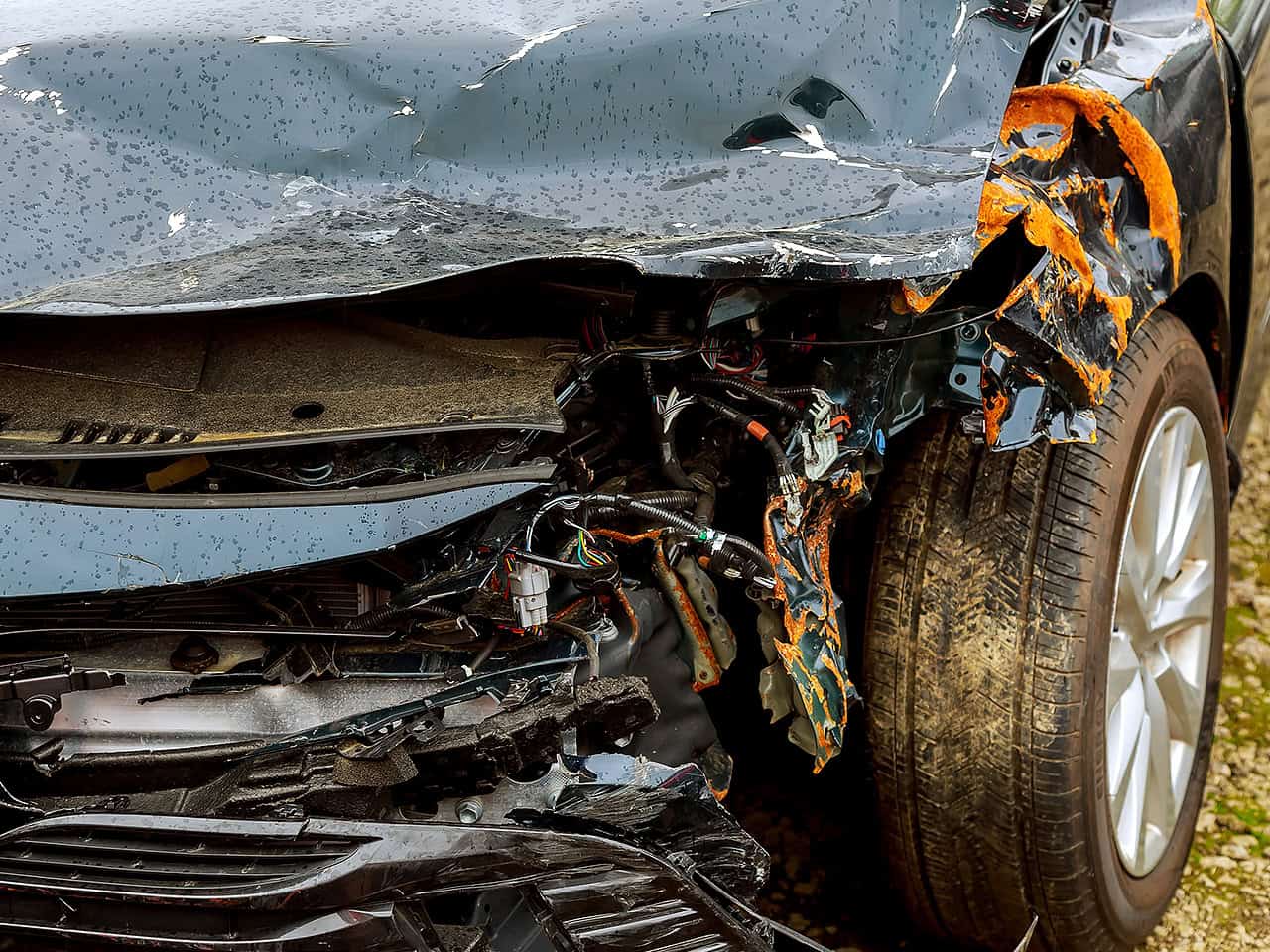 Damaged black car totaled after an accident