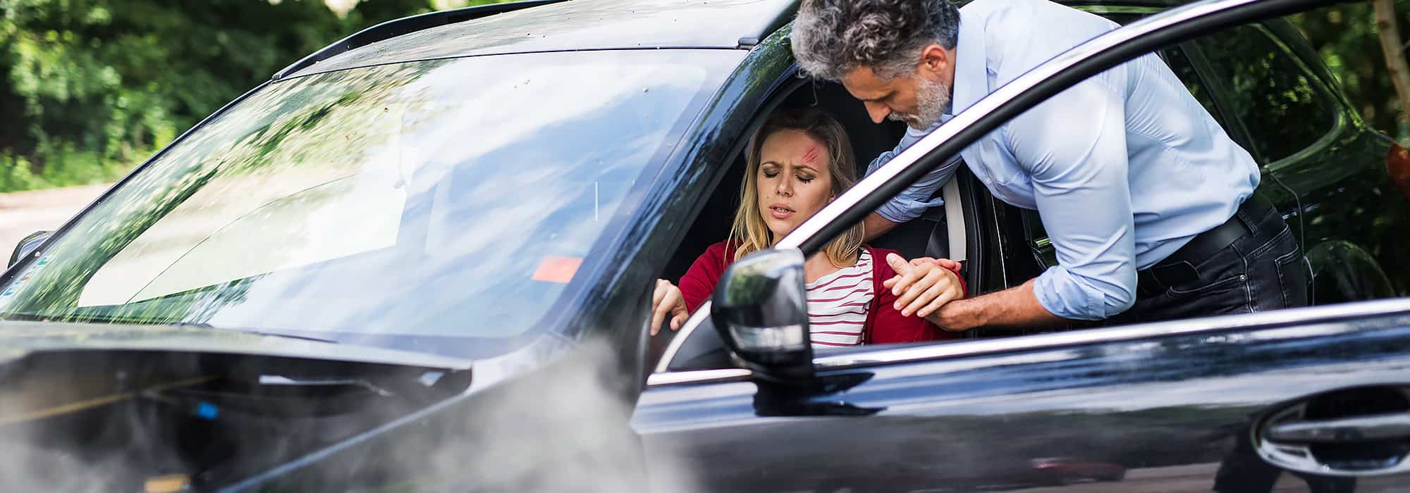 Man helping injured woman after a crash