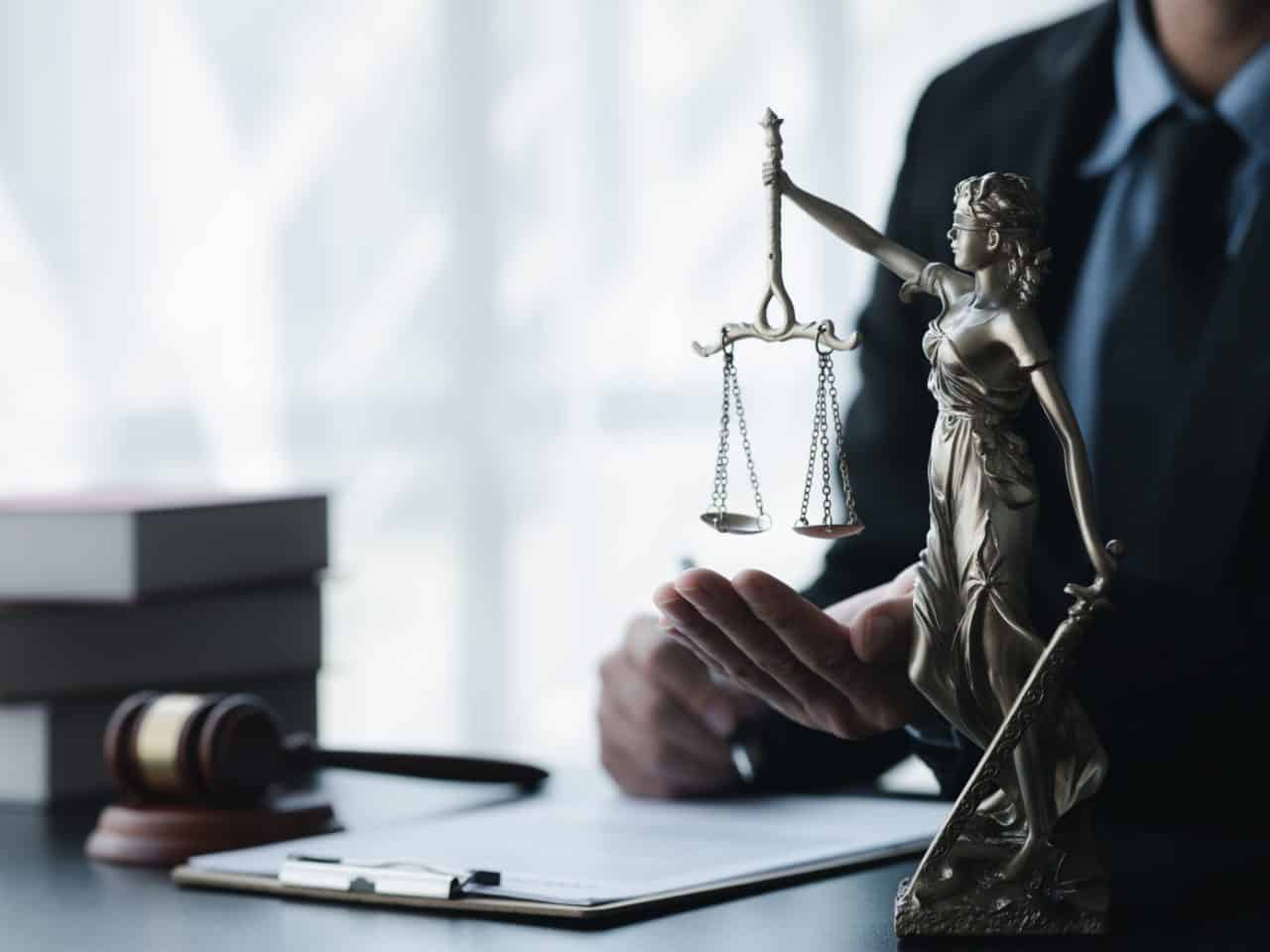 Scales of justice statue in legal office setting